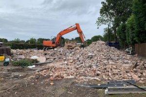 Excavator clearing rubble
